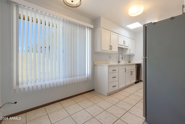 kitchen with dishwasher, light tile patterned floors, white cabinetry, and fridge