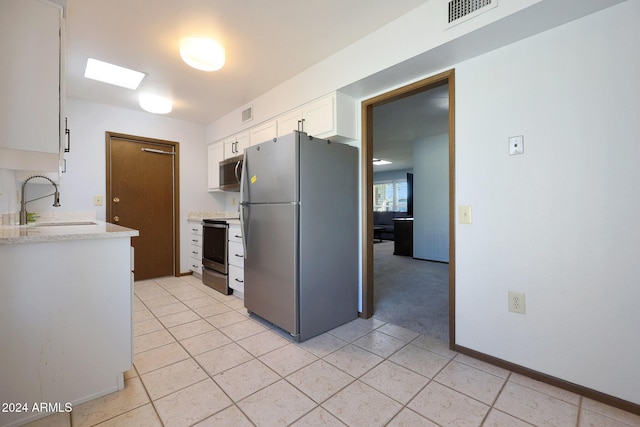 kitchen featuring white cabinets, light tile patterned floors, stainless steel appliances, and sink