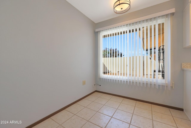 tiled spare room with lofted ceiling