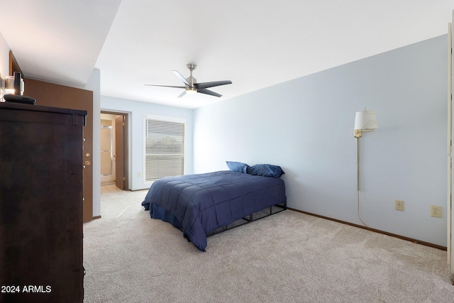 bedroom with connected bathroom, light colored carpet, and ceiling fan