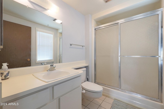 bathroom with toilet, tile patterned flooring, vanity, and walk in shower