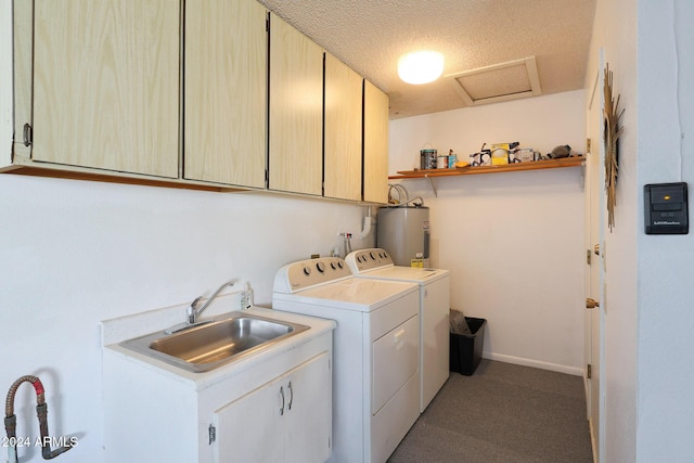 clothes washing area with cabinets, a textured ceiling, electric water heater, sink, and washing machine and clothes dryer