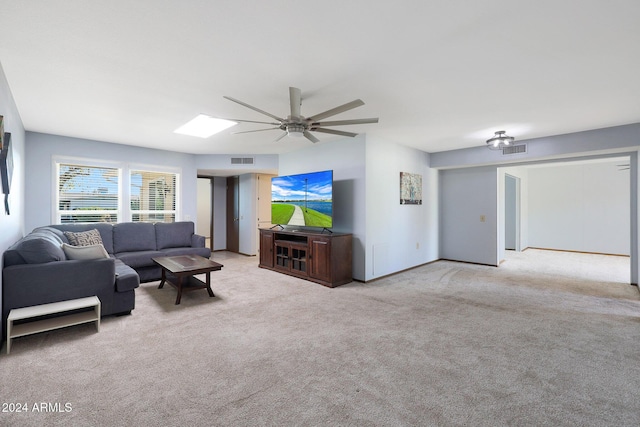 carpeted living room featuring a skylight and ceiling fan