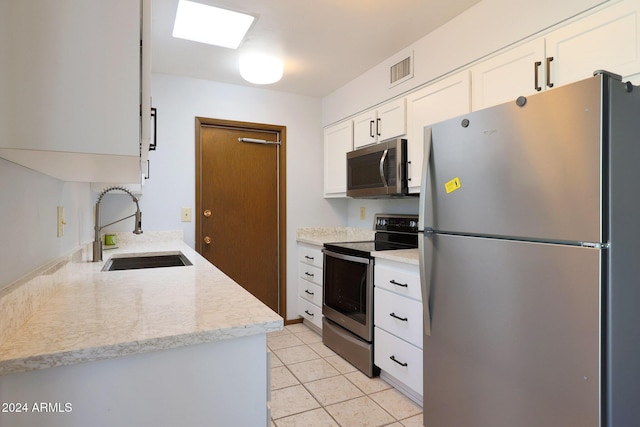 kitchen featuring white cabinets, appliances with stainless steel finishes, light tile patterned flooring, and sink