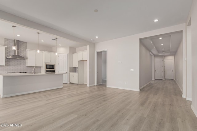 unfurnished living room featuring light hardwood / wood-style flooring and sink