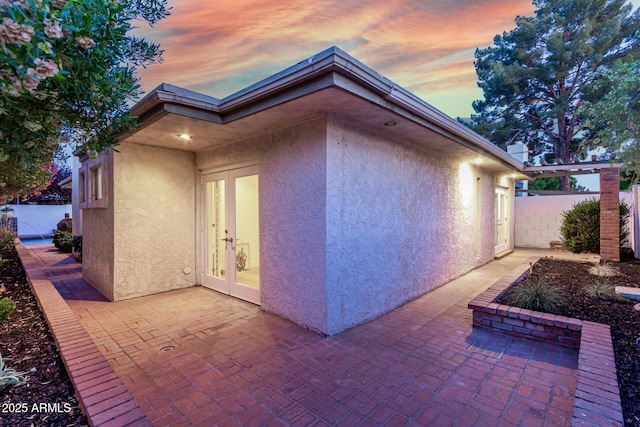 106 E Echo Ln, Phoenix, AZ 85020 - property exterior at dusk with stucco siding, french doors, fence, and a patio