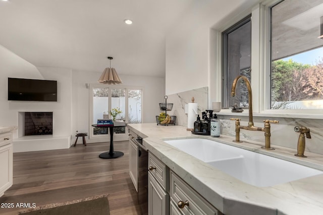 106 E Echo Ln, Phoenix, AZ 85020 - kitchen with a sink, a fireplace, dark wood-style flooring, light stone counters, and lofted ceiling
