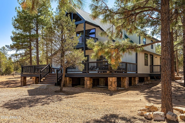 rear view of house with a balcony and a wooden deck