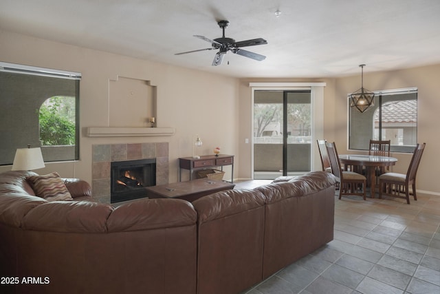 tiled living room with healthy amount of natural light, ceiling fan, and baseboards
