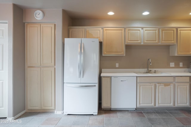 kitchen featuring white appliances, a sink, light countertops, recessed lighting, and light brown cabinetry