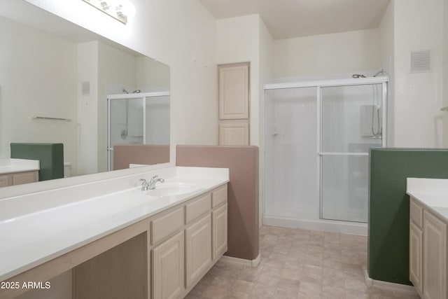 bathroom with a shower stall and vanity