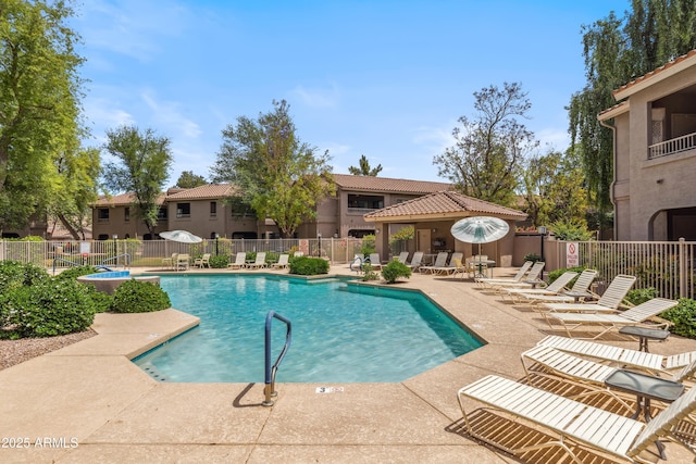 community pool with fence and a patio area