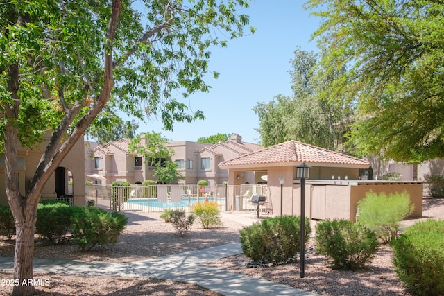 view of property's community featuring fence, a pool, and a gazebo