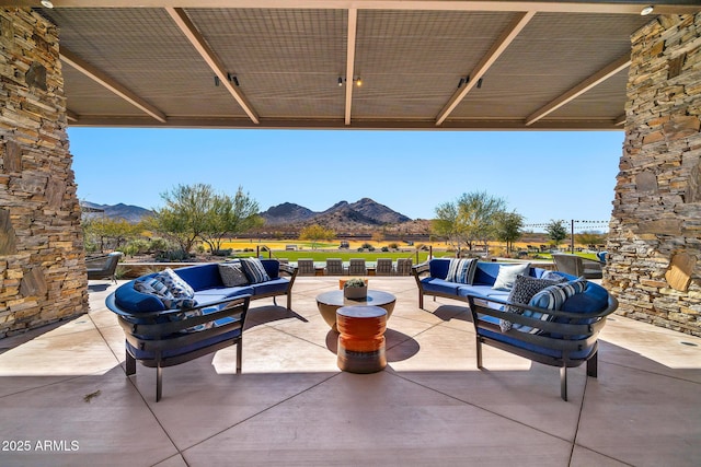 view of patio / terrace with an outdoor living space and a mountain view