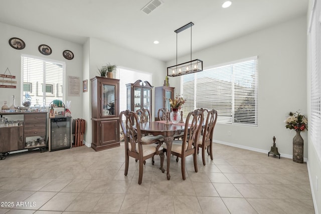 dining room with wine cooler, light tile patterned floors, and a notable chandelier