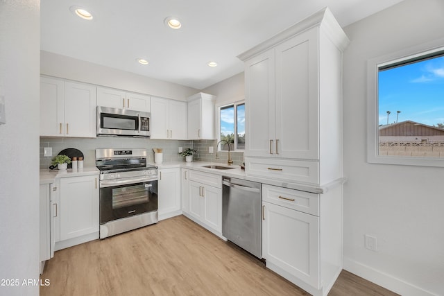 4720 W Northview Ave, Glendale, AZ 85301 - kitchen featuring appliances with stainless steel finishes, a sink, tasteful backsplash, light wood-style floors, and light countertops