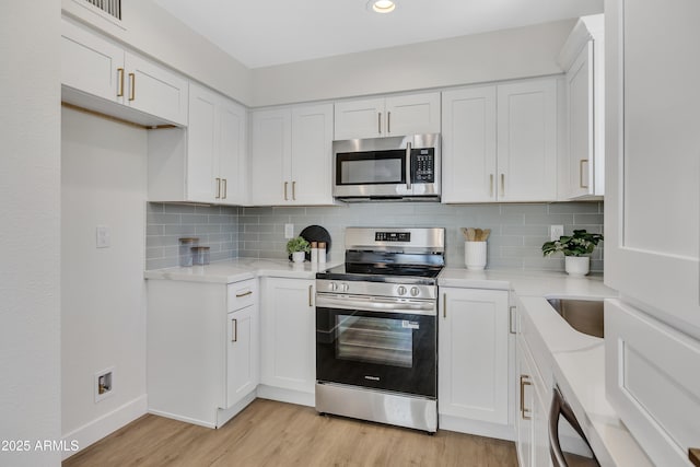 4720 W Northview Ave, Glendale, AZ 85301 - kitchen featuring appliances with stainless steel finishes, light wood-type flooring, white cabinetry, decorative backsplash, and recessed lighting