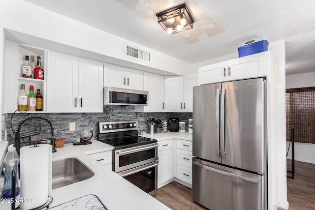 3829 W Camino Del Rio, Glendale, AZ 85310 - kitchen featuring stainless steel appliances, open shelves, dark wood finished floors, tasteful backsplash, and white cabinetry