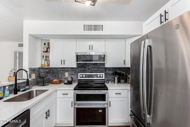 3829 W Camino Del Rio, Glendale, AZ 85310 - kitchen featuring appliances with stainless steel finishes, a sink, open shelves, a textured ceiling, and light countertops