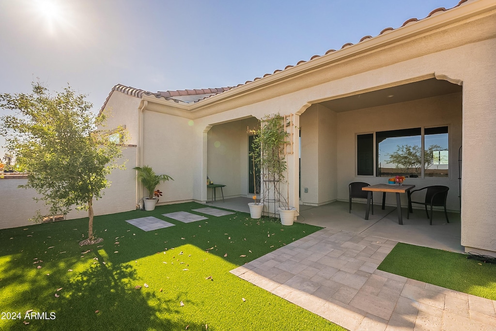 rear view of house with a patio area and a yard