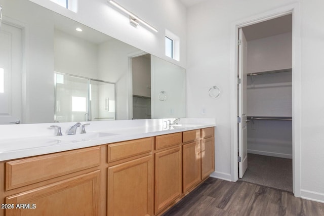 bathroom featuring an enclosed shower, vanity, and wood-type flooring