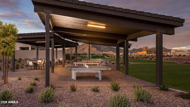 view of community with a mountain view, a yard, and a patio area