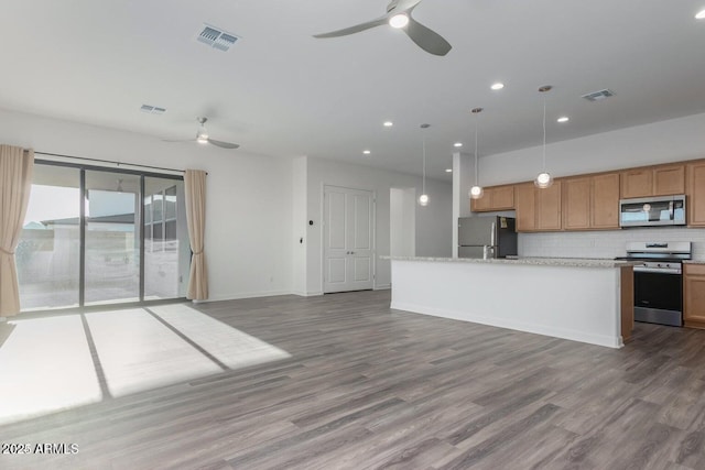 kitchen featuring pendant lighting, stainless steel appliances, wood-type flooring, and backsplash