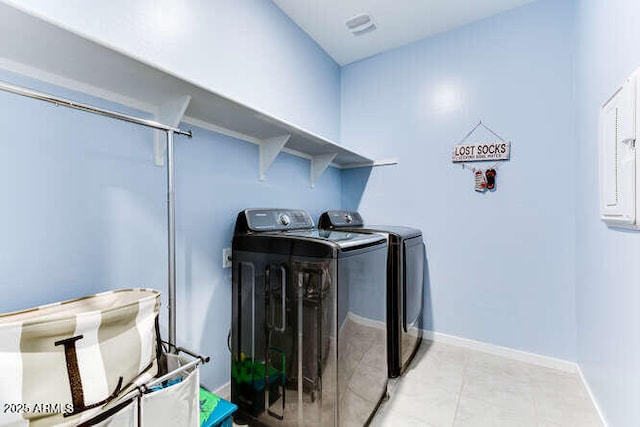 laundry area with light tile patterned floors and washing machine and clothes dryer