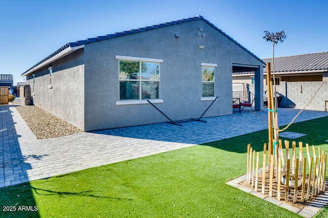 rear view of property featuring a yard and a patio area