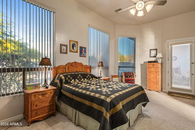 carpeted bedroom featuring multiple windows and ceiling fan