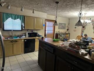 kitchen featuring light tile patterned floors, hanging light fixtures, a sink, a textured ceiling, and black appliances