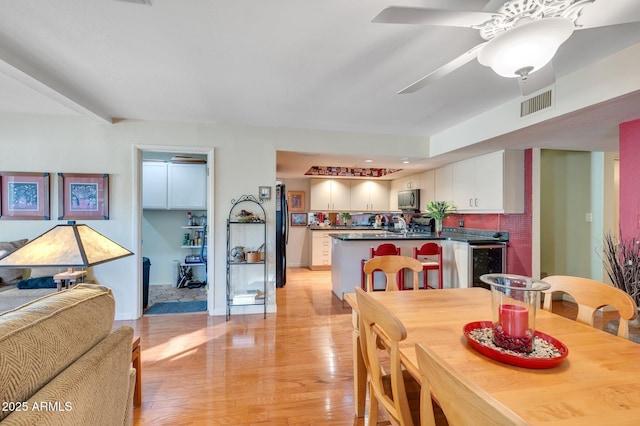 dining room with ceiling fan, light hardwood / wood-style floors, and wine cooler