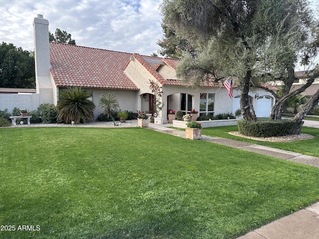 mediterranean / spanish home featuring an attached garage, a tiled roof, stucco siding, a chimney, and a front yard