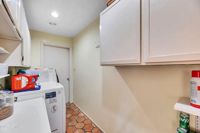 laundry area with dark tile patterned floors, separate washer and dryer, and cabinets