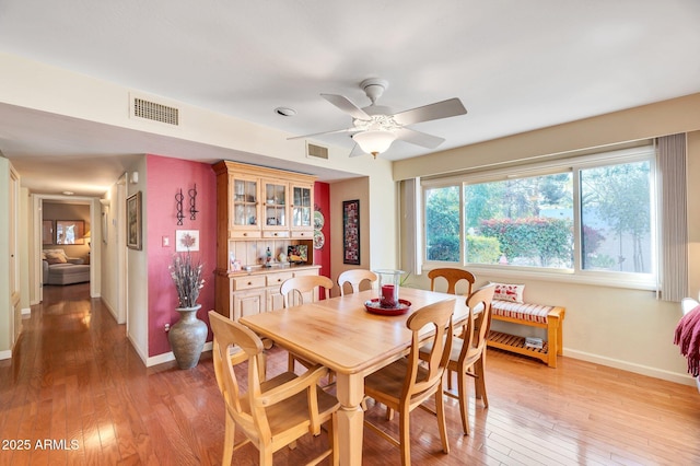 dining space with ceiling fan and light hardwood / wood-style floors