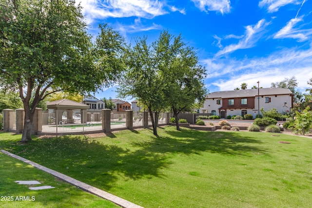 view of property's community featuring a lawn, a gazebo, and fence