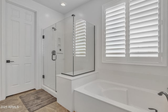 full bathroom featuring a garden tub and a stall shower