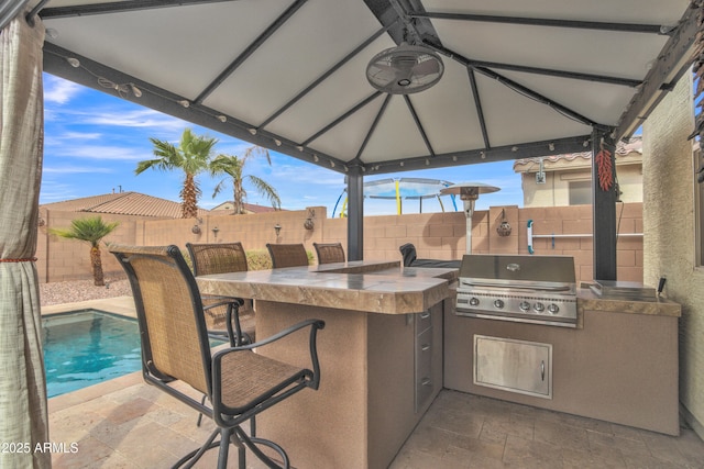 view of patio featuring outdoor wet bar, area for grilling, exterior kitchen, and a fenced backyard