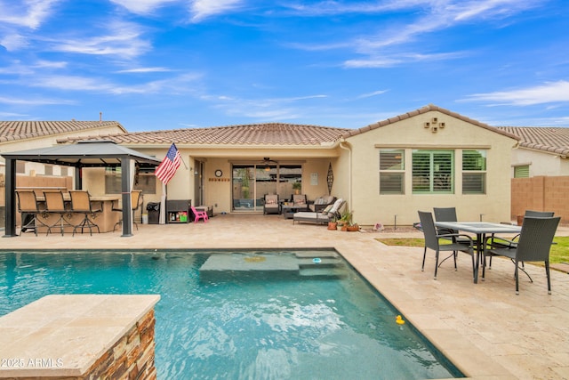 pool featuring outdoor dry bar, a ceiling fan, a patio, fence, and an outdoor hangout area