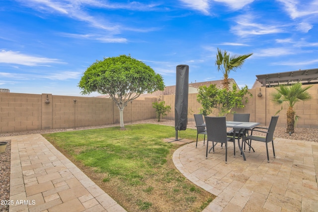 view of yard featuring outdoor dining space, a patio, and a fenced backyard