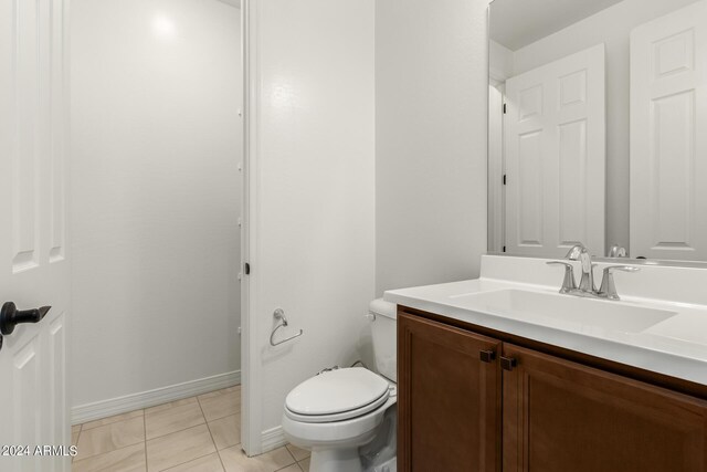 bathroom featuring tile patterned flooring, toilet, and vanity