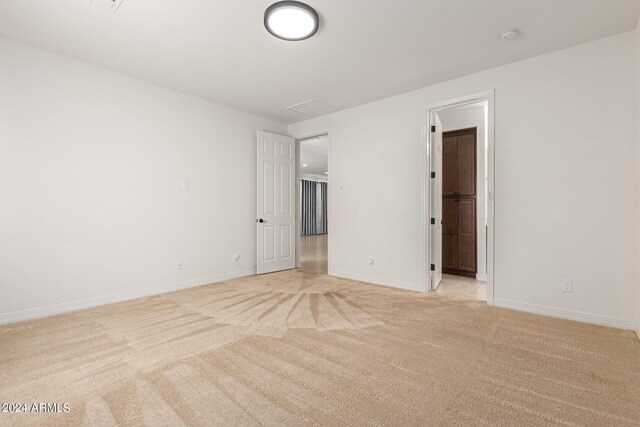 spare room featuring light carpet