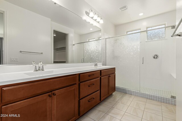 bathroom with tile patterned flooring, an enclosed shower, and vanity