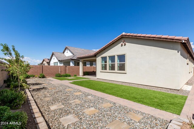 rear view of house with a yard and a patio area