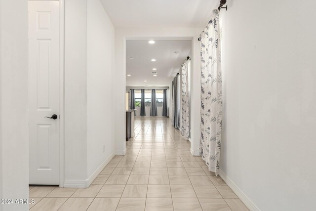 hall with light tile patterned floors