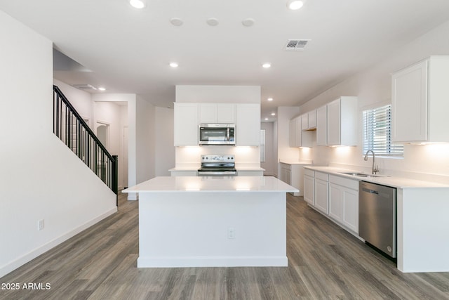 kitchen featuring a kitchen island, appliances with stainless steel finishes, sink, and white cabinets