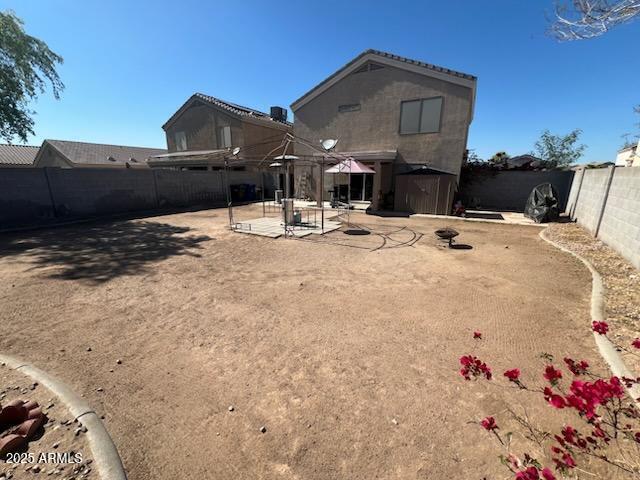 12517 W Santa Fe Ln, El Mirage, AZ 85335 - back of property with a fenced backyard and a patio area