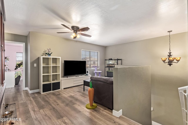 12517 W Santa Fe Ln, El Mirage, AZ 85335 - living area with ceiling fan with notable chandelier, baseboards, and wood finished floors