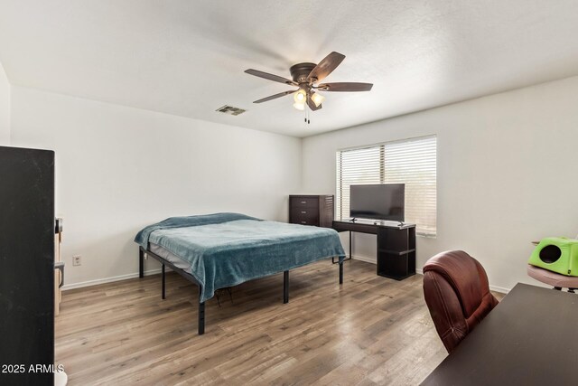 12517 W Santa Fe Ln, El Mirage, AZ 85335 - bedroom with baseboards, wood finished floors, visible vents, and a ceiling fan