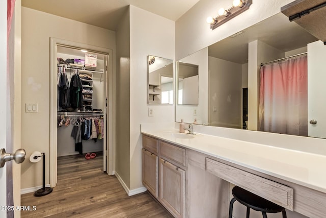 12517 W Santa Fe Ln, El Mirage, AZ 85335 - bathroom with baseboards, wood finished floors, vanity, and a walk in closet